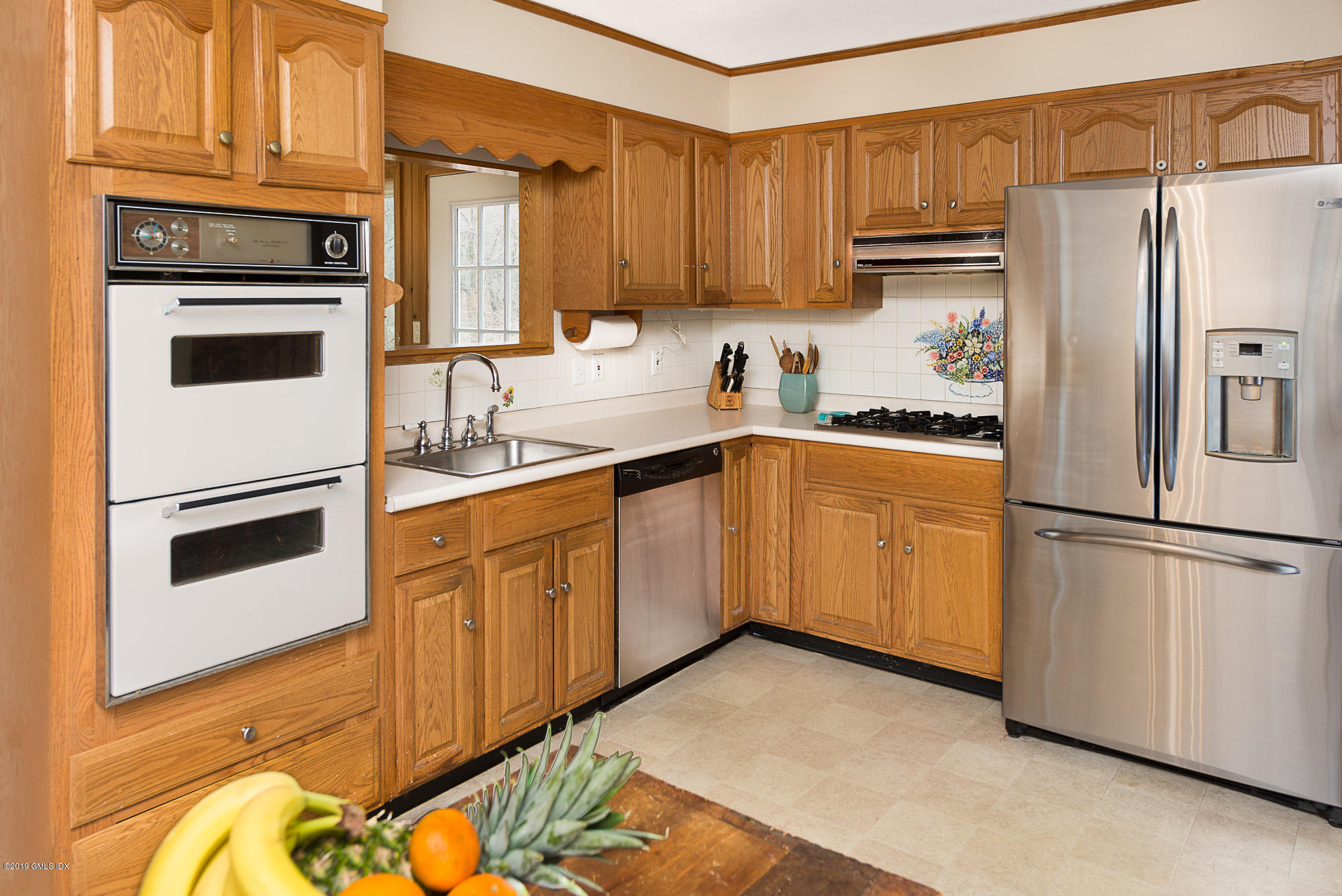 81 Mary Lane Riverside, CT 06878 - Photo 6 of 26 a kitchen with a refrigerator sink and white cabinets