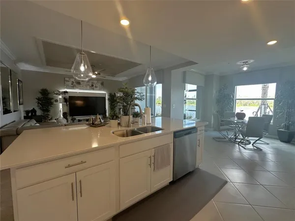 a kitchen with stainless steel appliances granite countertop a table chairs sink and cabinets
