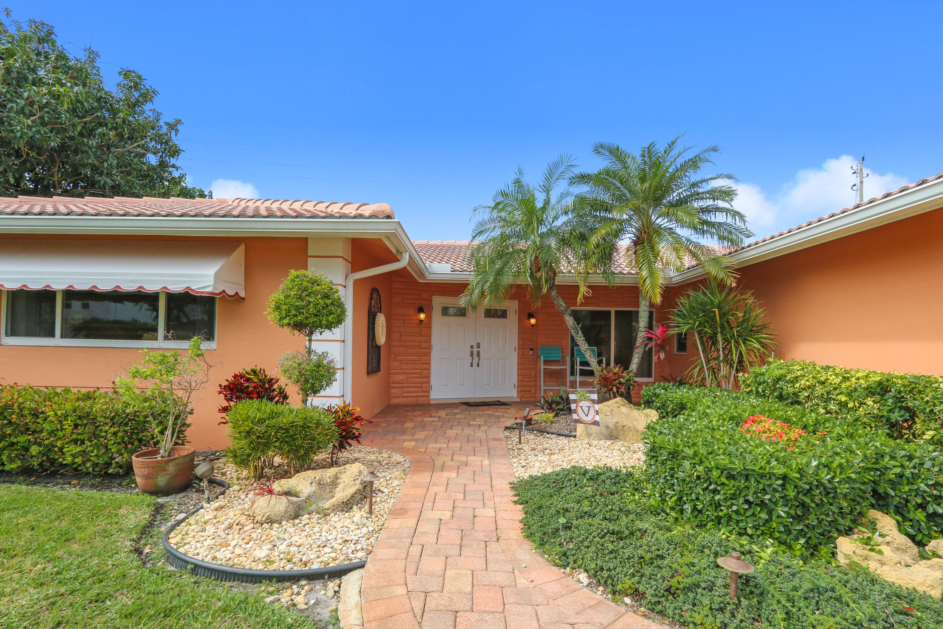 3533 Northeast 6th Drive Boca Raton, FL 33431 - Photo 2 of 23 a front view of a house with garden