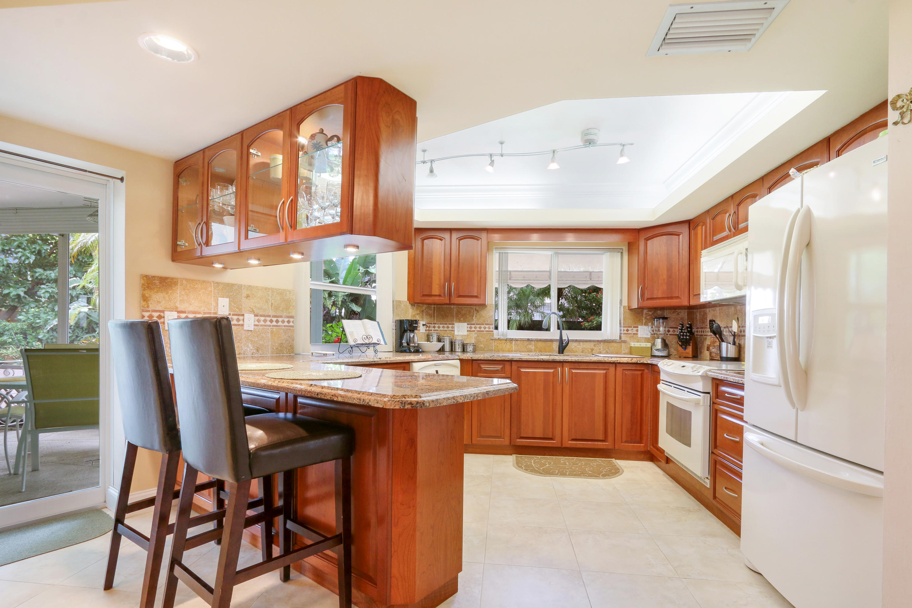 3533 Northeast 6th Drive Boca Raton, FL 33431 - Photo 10 of 23 a kitchen with stainless steel appliances granite countertop a stove a refrigerator a sink dishwasher with a dining table and chairs