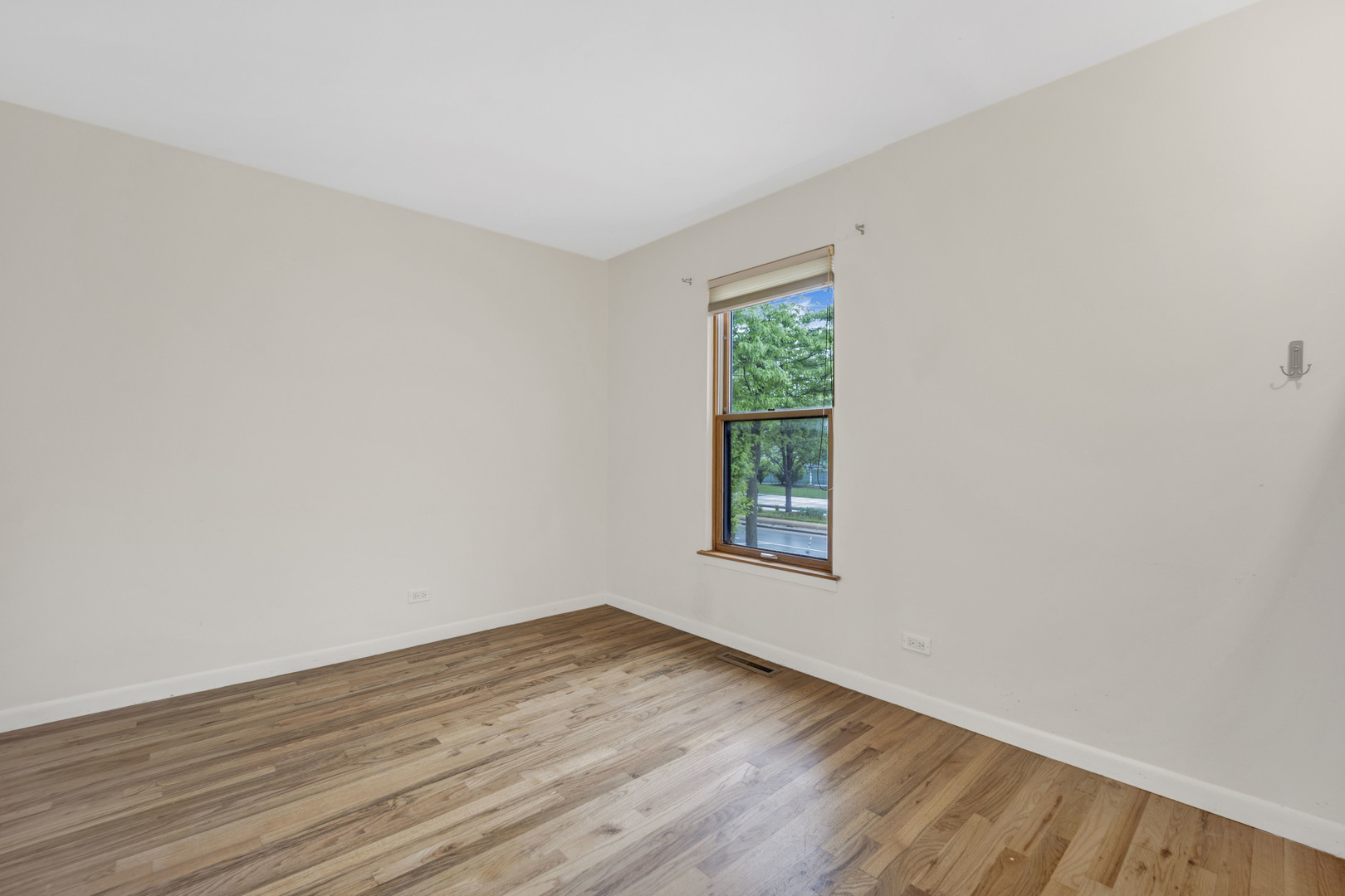 1252 West Westgate Terrace Chicago, IL 60607 - Photo 13 of 24 a view of an empty room with wooden floor and a window