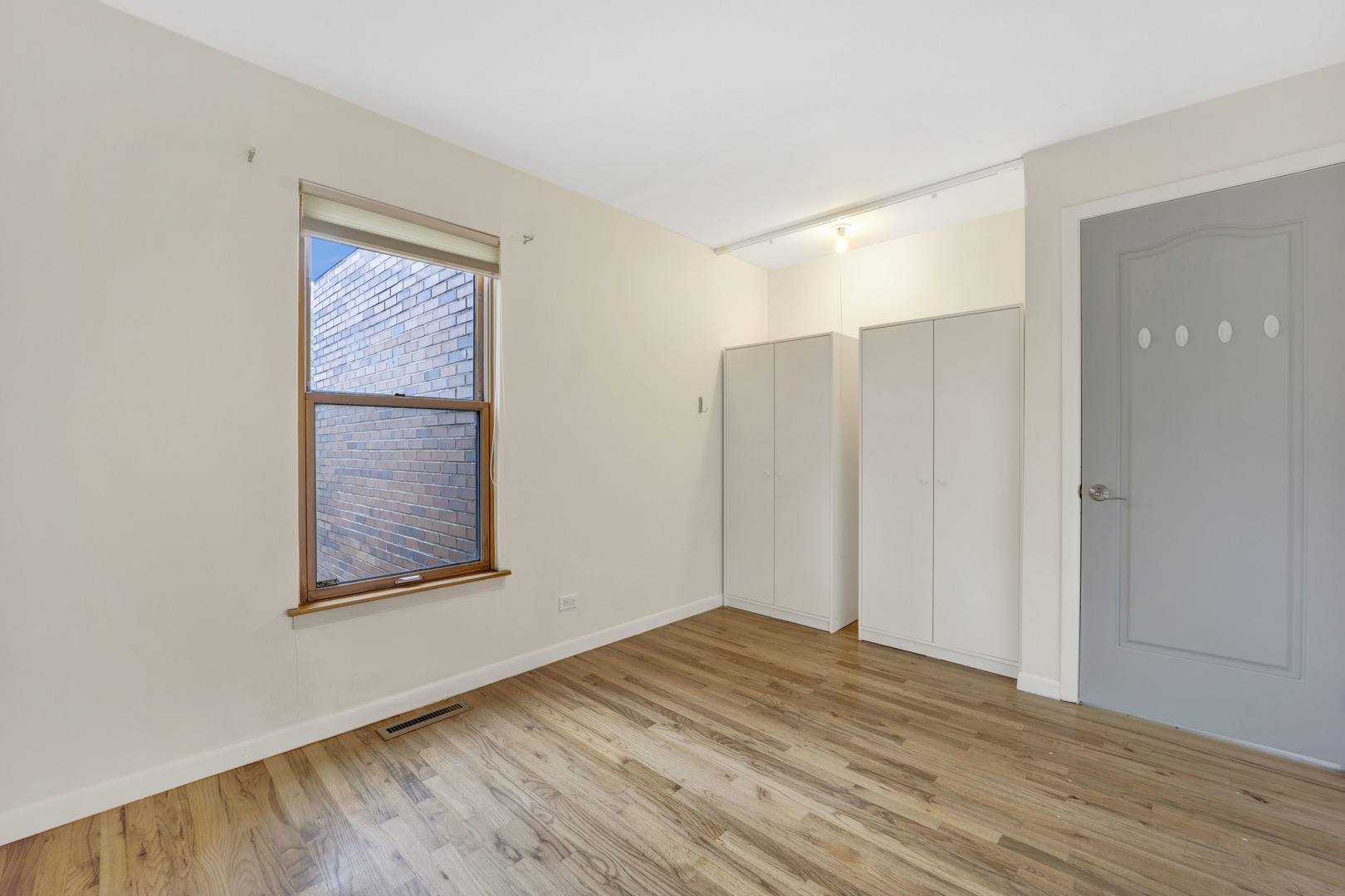 1252 West Westgate Terrace Chicago, IL 60607 - Photo 14 of 24 a view of an empty room with wooden floor and a window