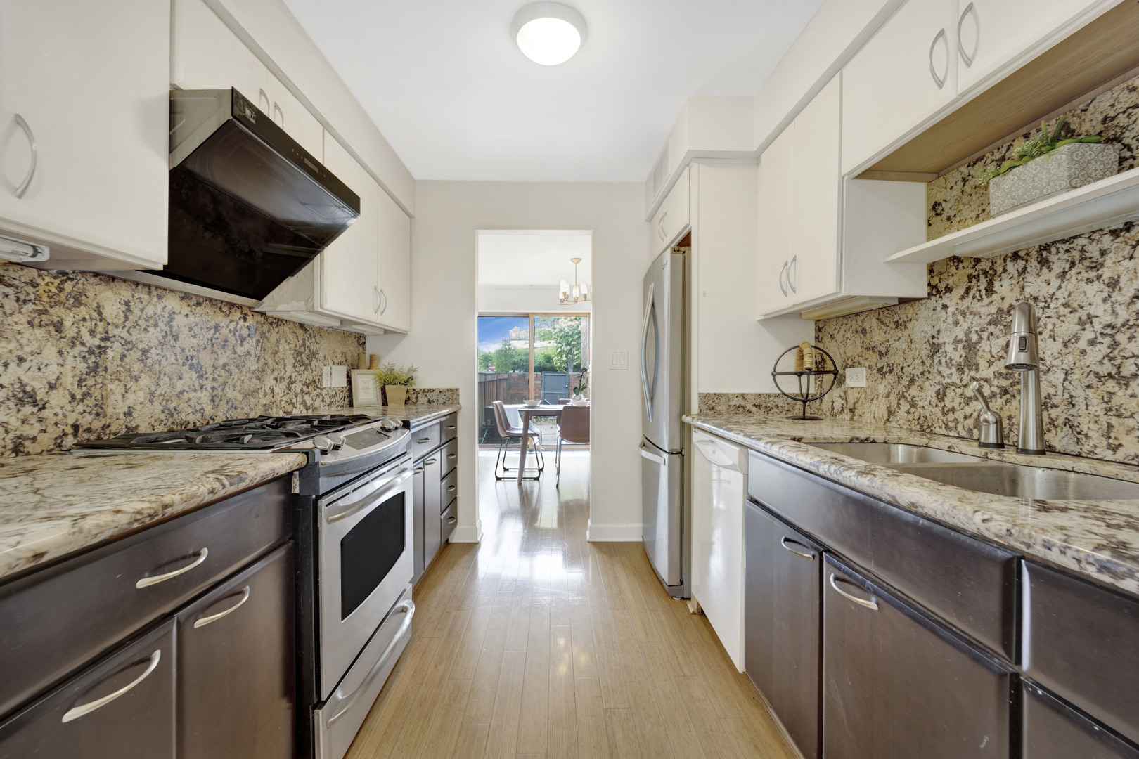 1252 West Westgate Terrace Chicago, IL 60607 - Photo 8 of 24 a kitchen with stainless steel appliances granite countertop a stove a sink and a microwave