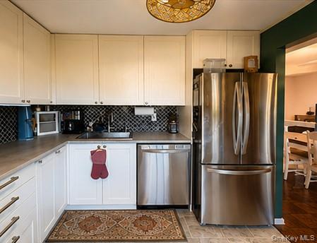 335 Mariners Way Copiague, NY 11726 - Photo 2 of 12 a kitchen with a refrigerator and a stove top oven