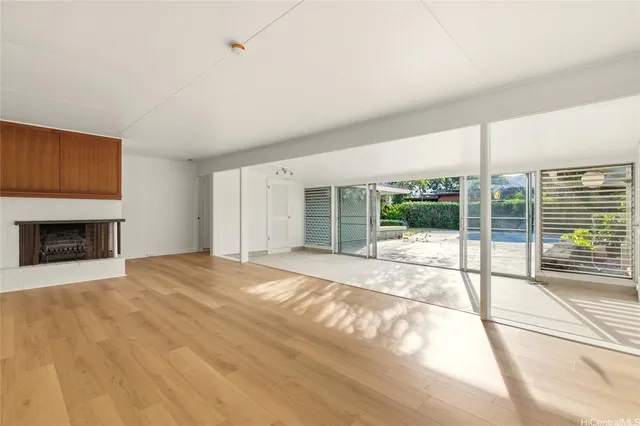 a view of an empty room with a fireplace and a window
