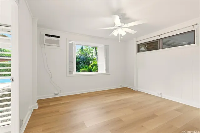an empty room with windows and fan