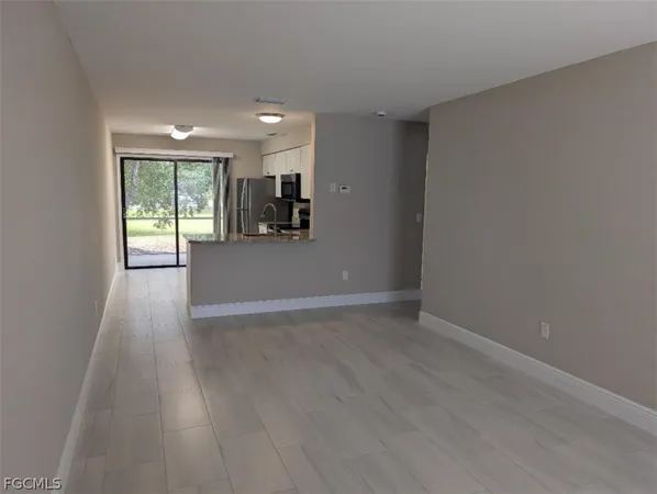 a view of empty room with wooden floor and window