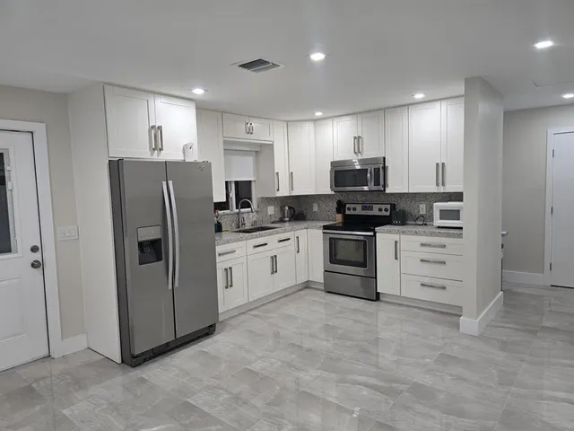 a kitchen with stainless steel appliances and white cabinets