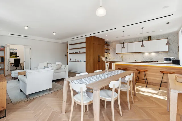a living room with furniture a fireplace a flat screen tv and a large window