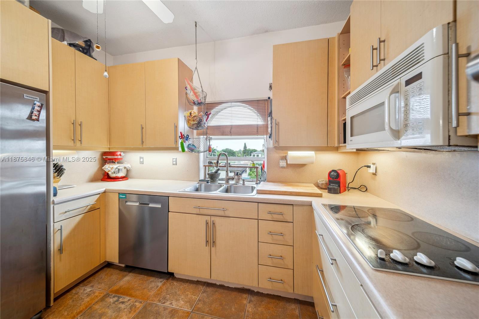 9008 Collins Avenue, Unit 402 Surfside, FL 33154 - Photo 16 of 49 a kitchen with a sink stove and cabinets