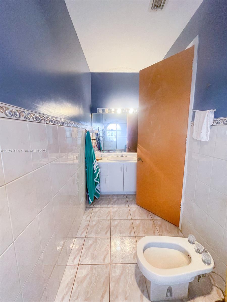 9008 Collins Avenue, Unit 402 Surfside, FL 33154 - Photo 25 of 49 a bathroom with a sink and a mirror