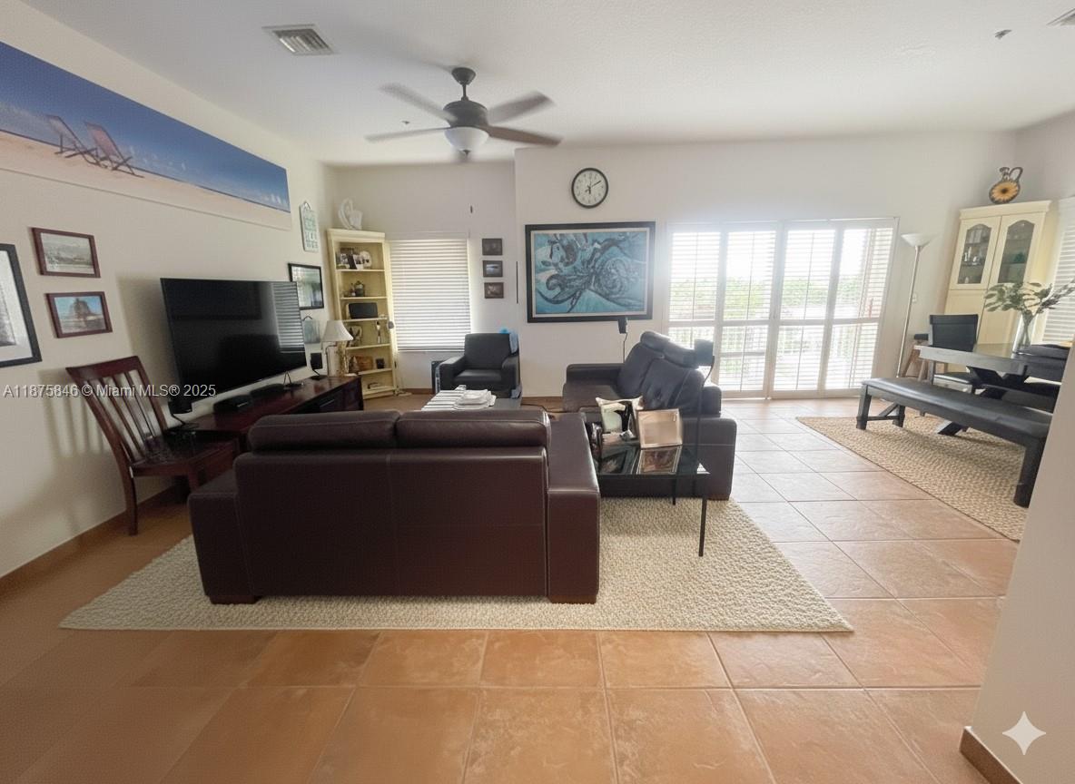 9008 Collins Avenue, Unit 402 Surfside, FL 33154 - Photo 6 of 49 a living room with furniture and a flat screen tv
