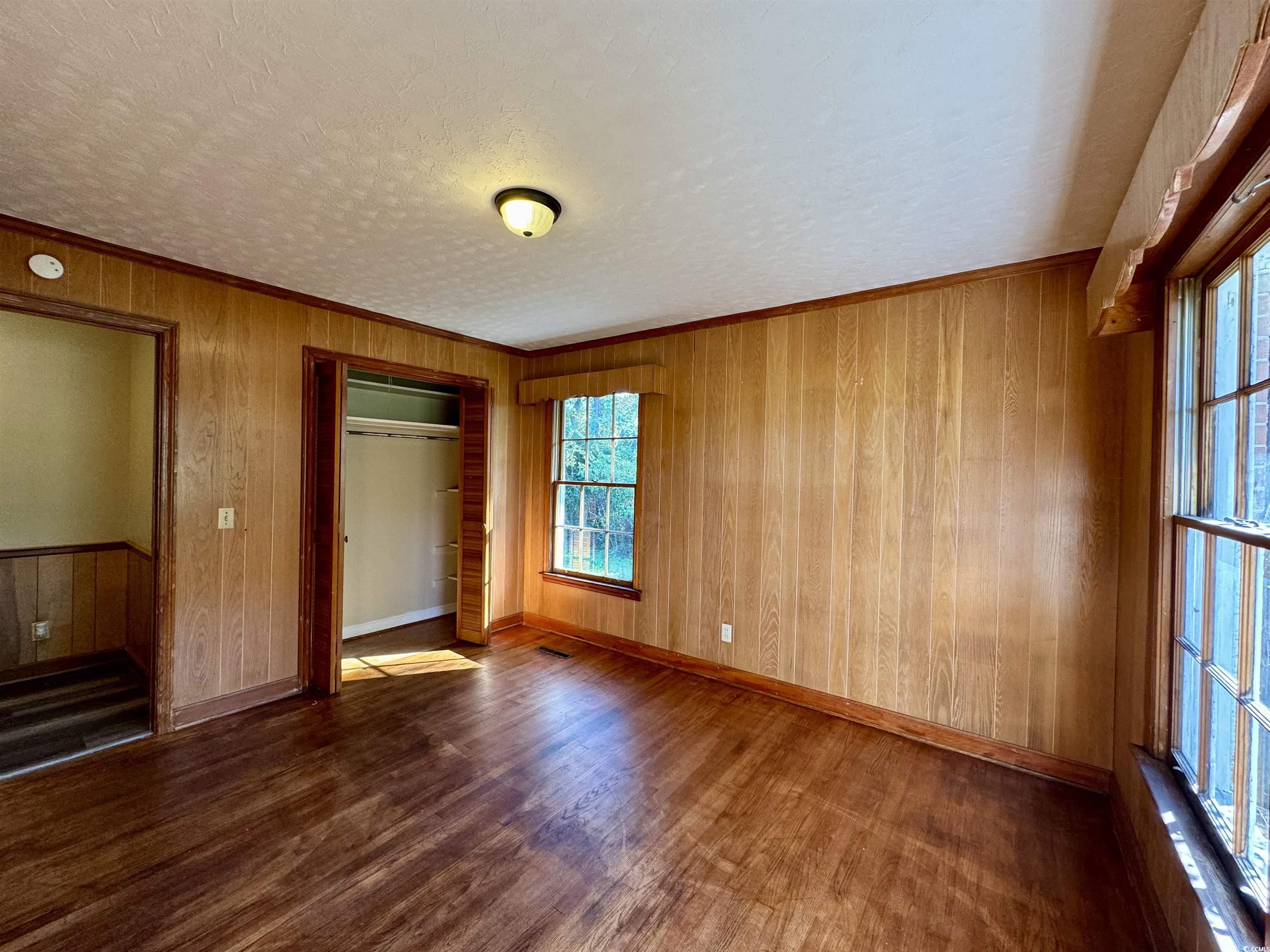 409 North Main Street Hemingway, SC 29554 - Photo 15 of 27 Unfurnished bedroom with wood walls, a textured ce