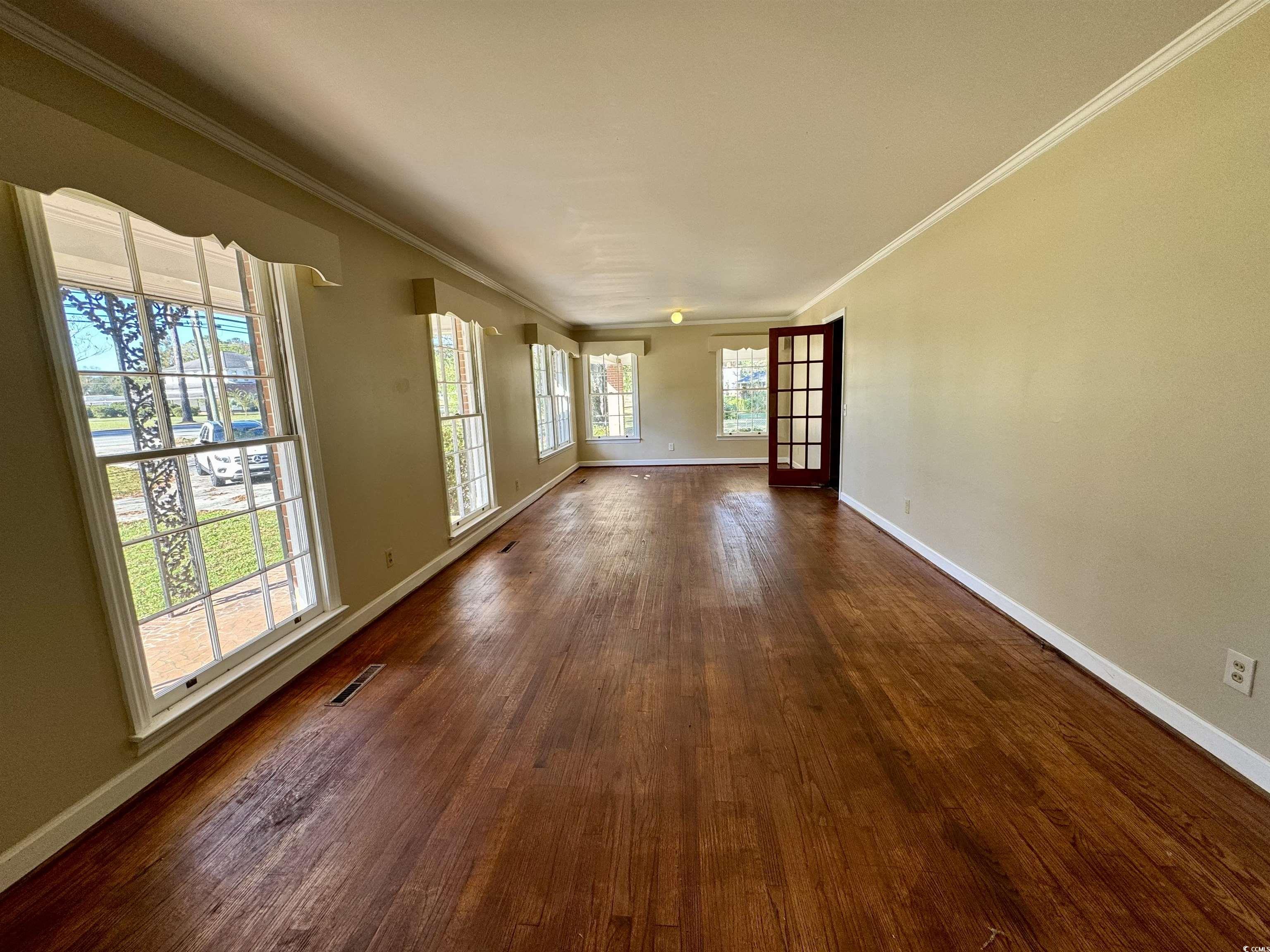 409 North Main Street Hemingway, SC 29554 - Photo 6 of 27 Spare room with dark wood-type flooring and crown