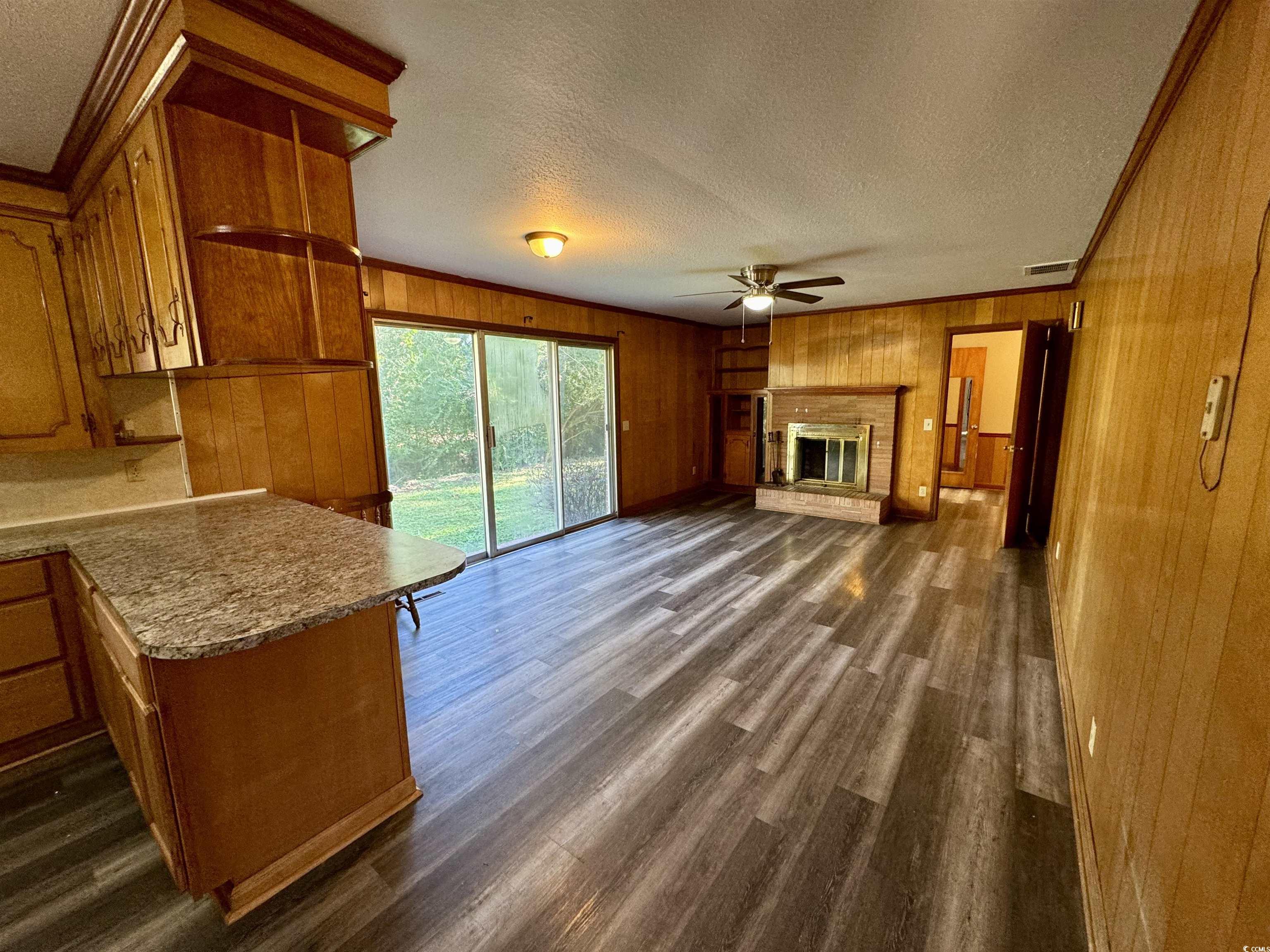 409 North Main Street Hemingway, SC 29554 - Photo 10 of 27 Unfurnished living room with wooden walls, a brick