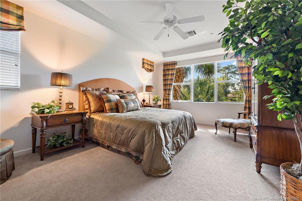 170 Southwest Walking Path Stuart, FL 34997 - Photo 12 of 18 a spacious bedroom with a bed and a chandelier