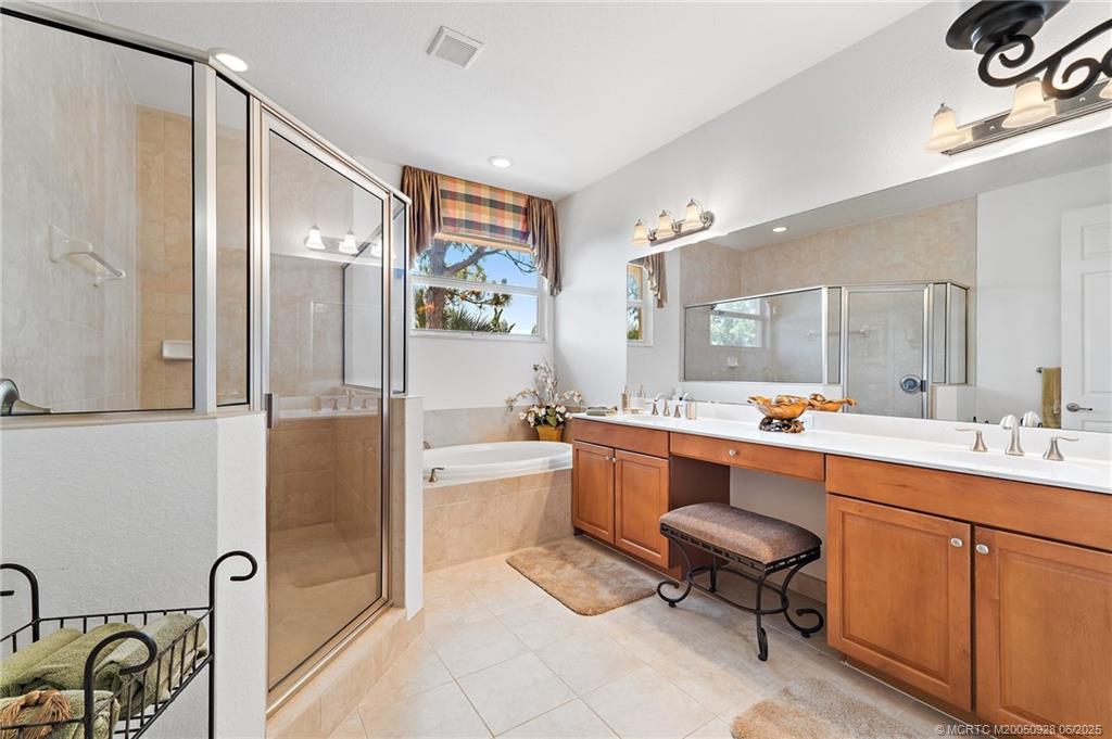 170 Southwest Walking Path Stuart, FL 34997 - Photo 13 of 18 a large bathroom with a double vanity sink a mirror a bathtub and shower