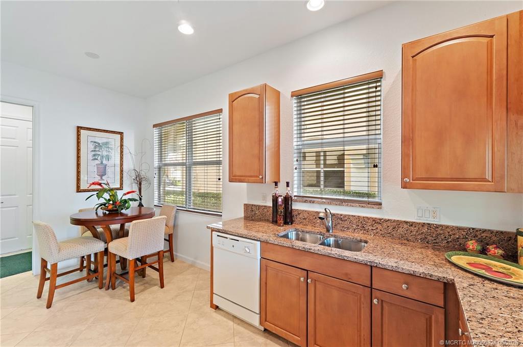 170 Southwest Walking Path Stuart, FL 34997 - Photo 6 of 18 a kitchen with granite countertop a sink and chairs