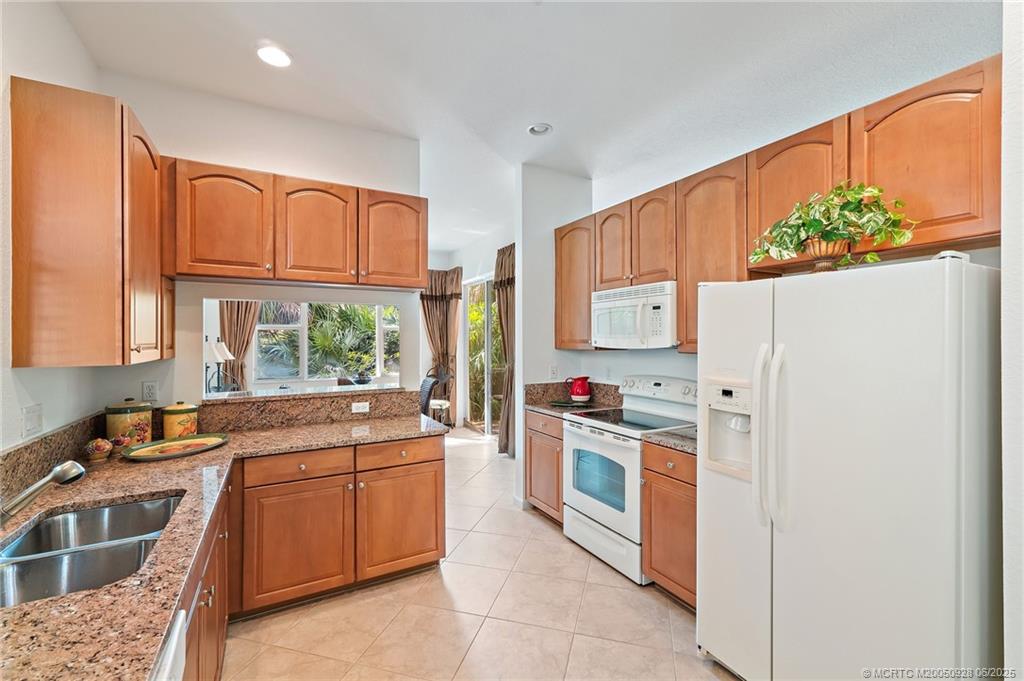 170 Southwest Walking Path Stuart, FL 34997 - Photo 7 of 18 a kitchen with stainless steel appliances a stove a sink and a refrigerator