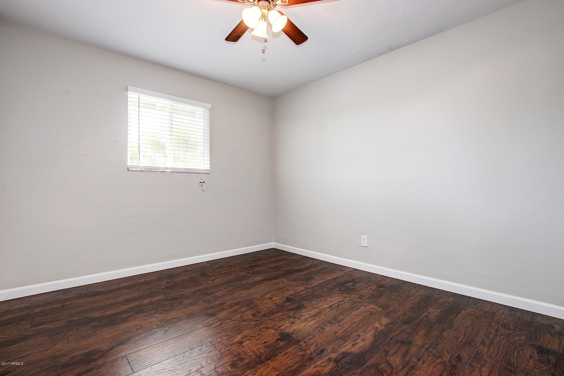 4844 East Coronado Road Phoenix, AZ 85008 - Photo 11 of 26 a view of an empty room with wooden floor and a window