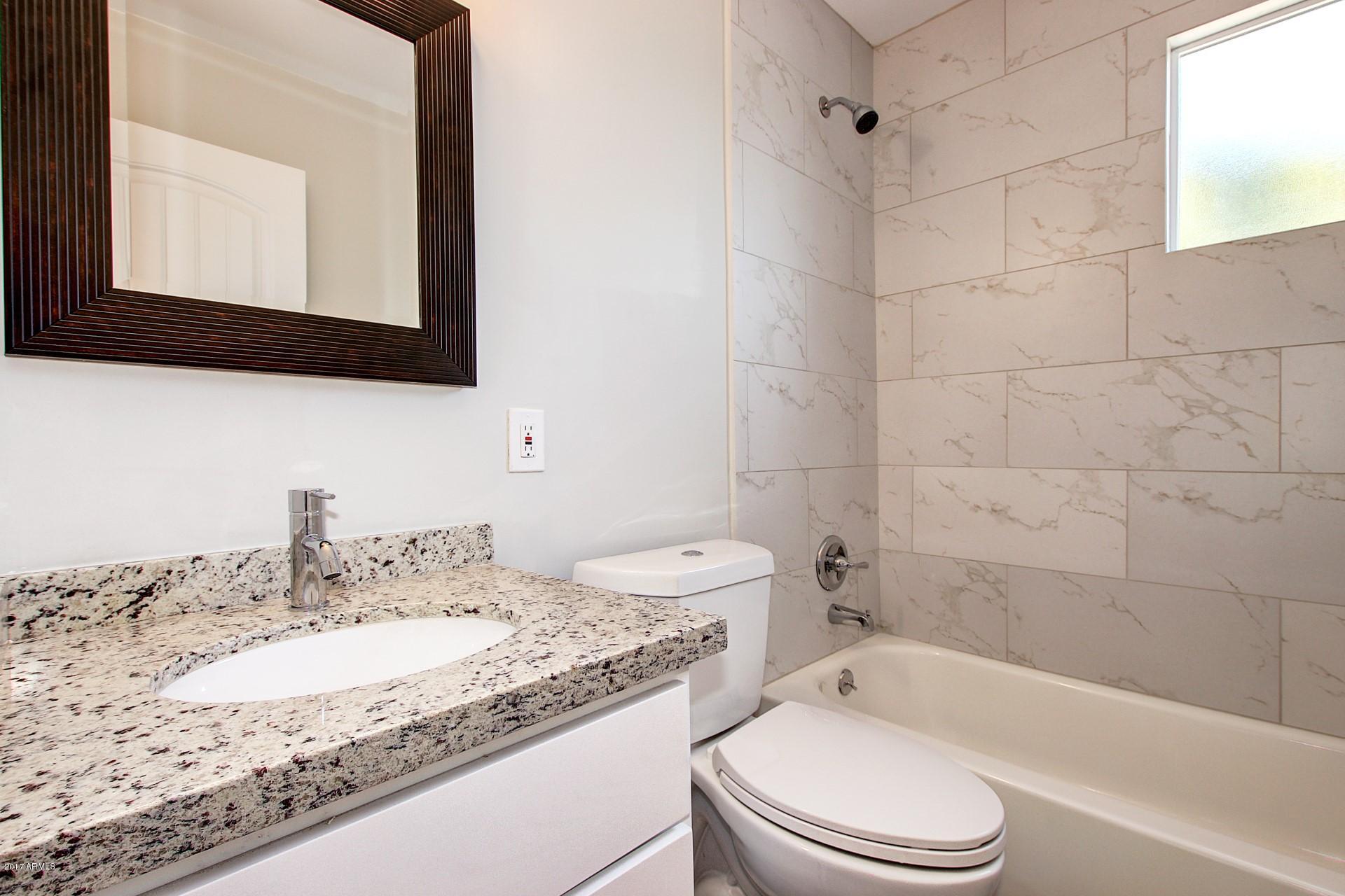 4844 East Coronado Road Phoenix, AZ 85008 - Photo 15 of 26 a bathroom with a granite countertop sink toilet mirror and bathtub