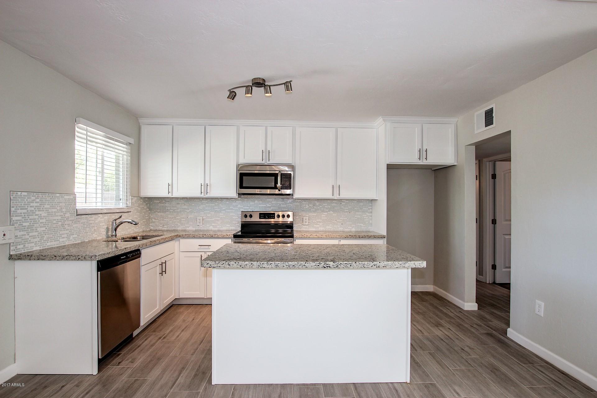4844 East Coronado Road Phoenix, AZ 85008 - Photo 8 of 26 a kitchen with stainless steel appliances granite countertop a stove a sink and a refrigerator