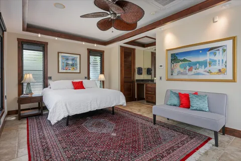 a spacious bedroom with a bed a rug and wooden floor