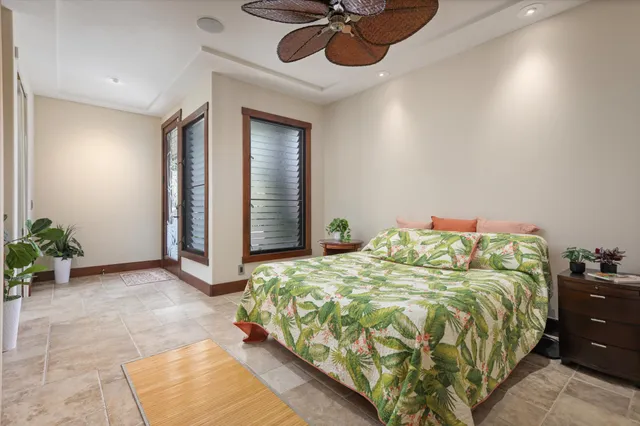 a bed sitting in a room next to a window and a chandelier