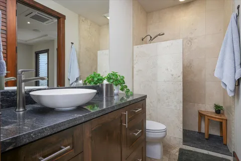 a view of a bathroom with a granite countertop sink a toilet a mirror and bathtub