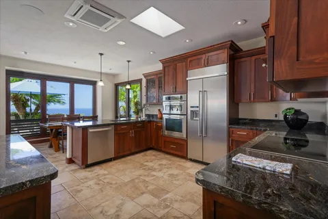 a kitchen with stainless steel appliances granite countertop a stove refrigerator and a sink