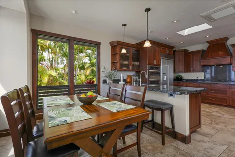 a dining room with wooden floor a chandelier a wooden table and chairs