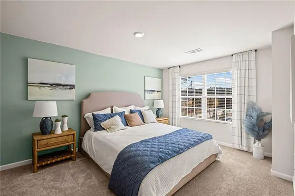 a bedroom with a bed lamp and a large window