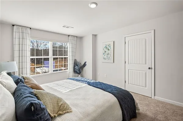 a bedroom with a bed and a large window