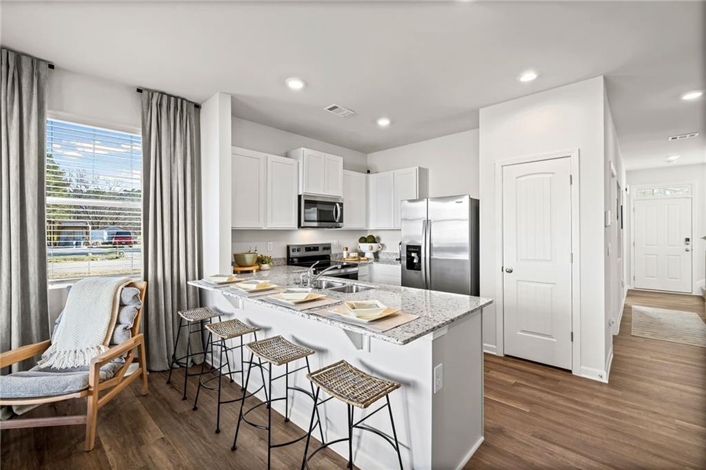 7 Silverbell Lane Northwest Rome, GA 30165 - Photo 3 of 24 a kitchen with a refrigerator a stove a dining table and chairs