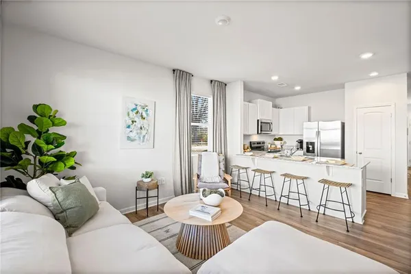 a living room with stainless steel appliances furniture a dining table and chairs