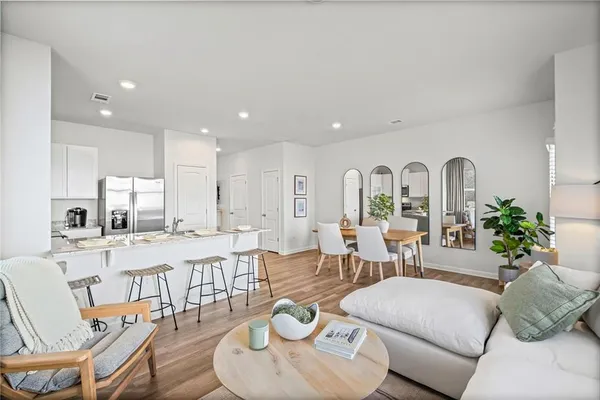 a living room with furniture kitchen view and large windows