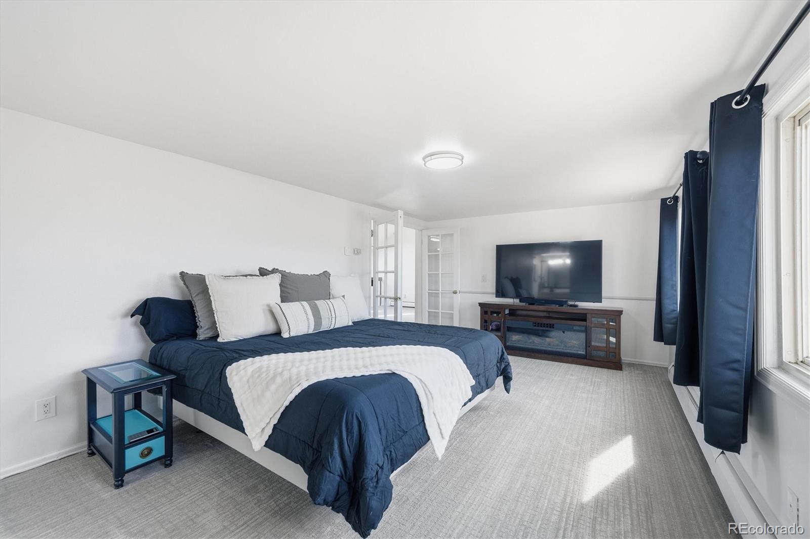 767 Ellis Street Golden, CO 80401 - Photo 23 of 50 a bedroom with a bed a flat screen tv and a couch