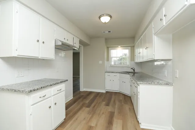 a kitchen with granite countertop white cabinets and white appliances