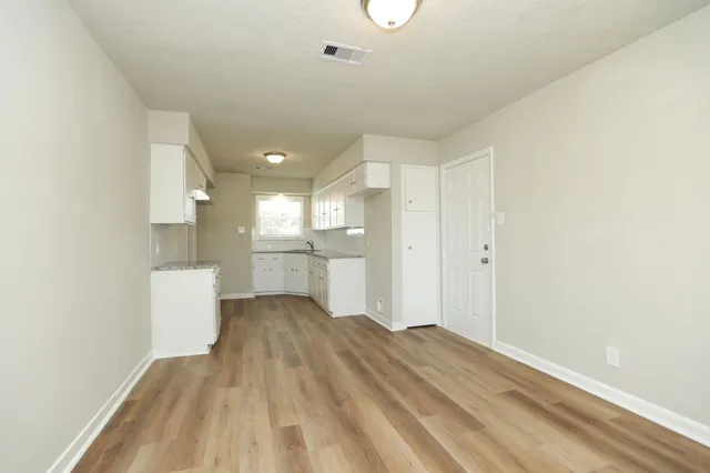 a view of a kitchen with wooden floor and a sink