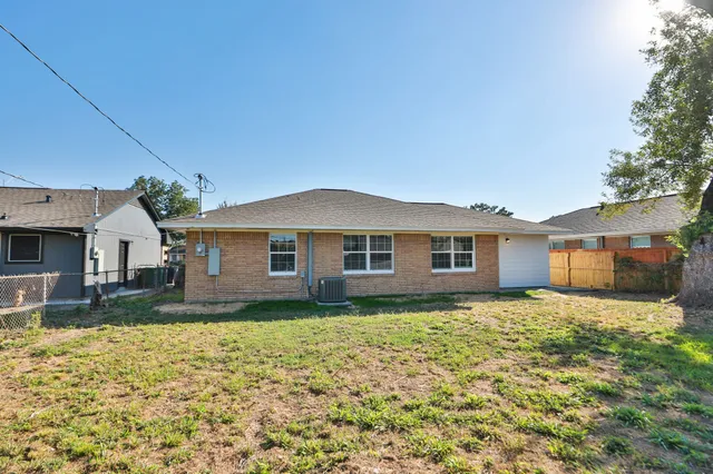 a view of a yard in front of a house with large tree