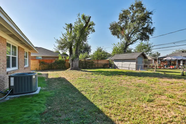 a front view of a house with a yard fountain and tree