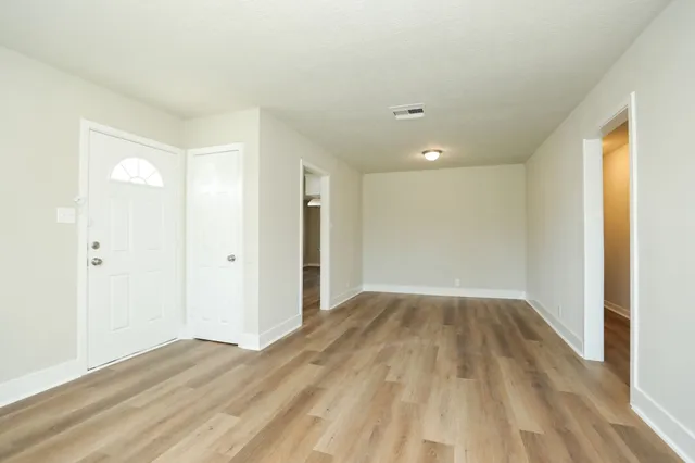 a view of an empty room and wooden floor
