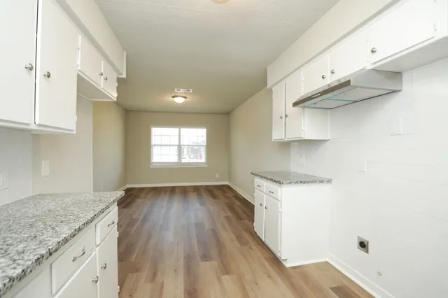 a kitchen with a hard wood floor and a stove top oven