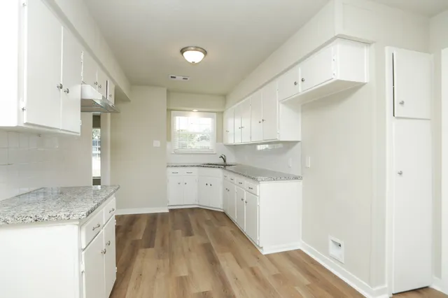 a kitchen with granite countertop white cabinets and white appliances