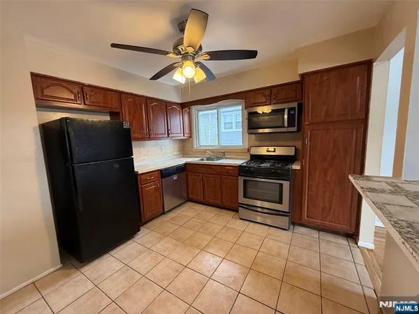a kitchen with granite countertop stainless steel appliances and a refrigerator