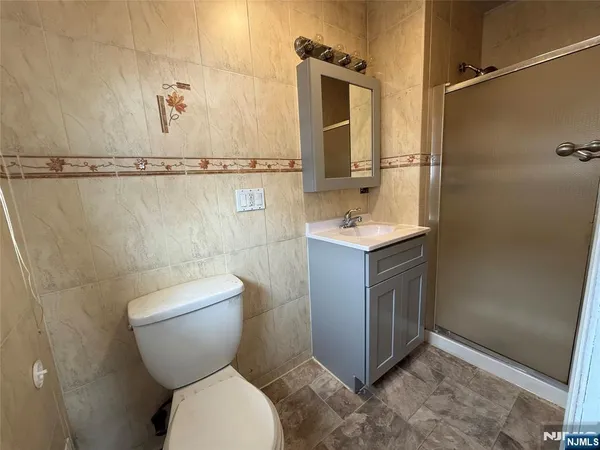 a bathroom with a granite countertop toilet sink and mirror