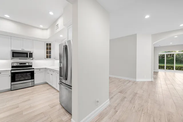 a kitchen with granite countertop a refrigerator and a stove top oven