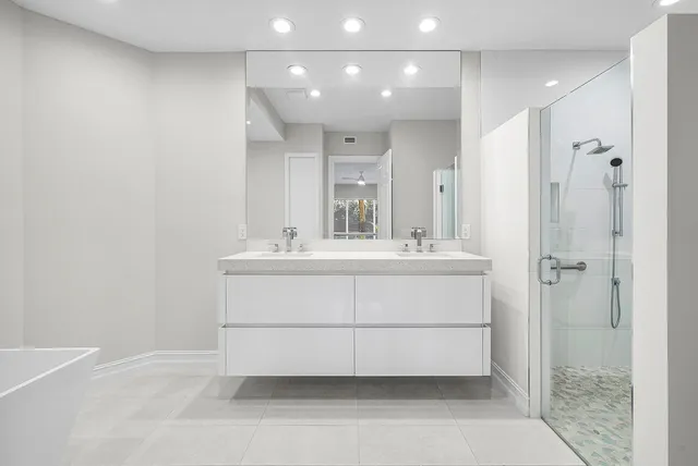 a bathroom with a sink shower and a mirror