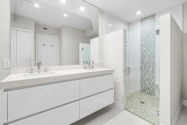 a bathroom with a shower sink and mirror