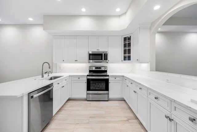 a kitchen with granite countertop a stove top oven and sink